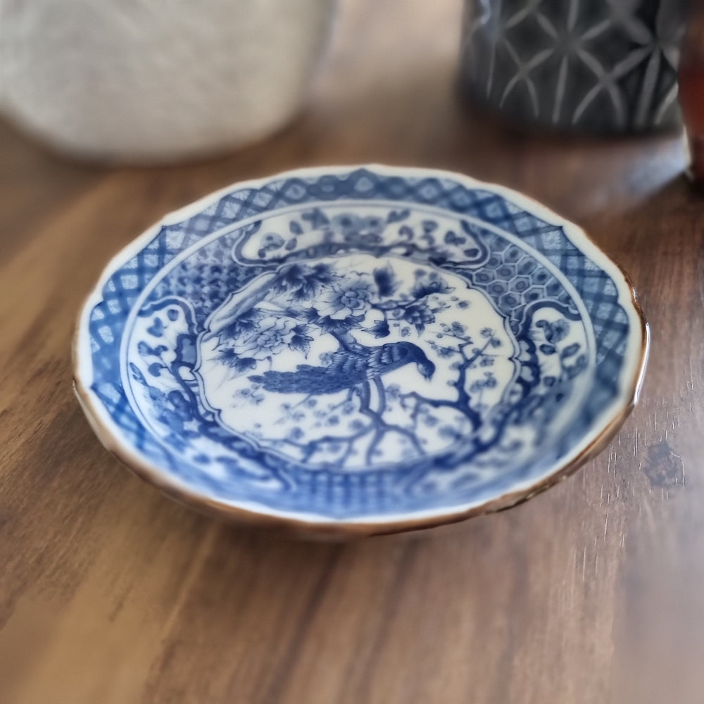 Vintage blue and white porcelain dish with bird and floral motif and scalloped edge