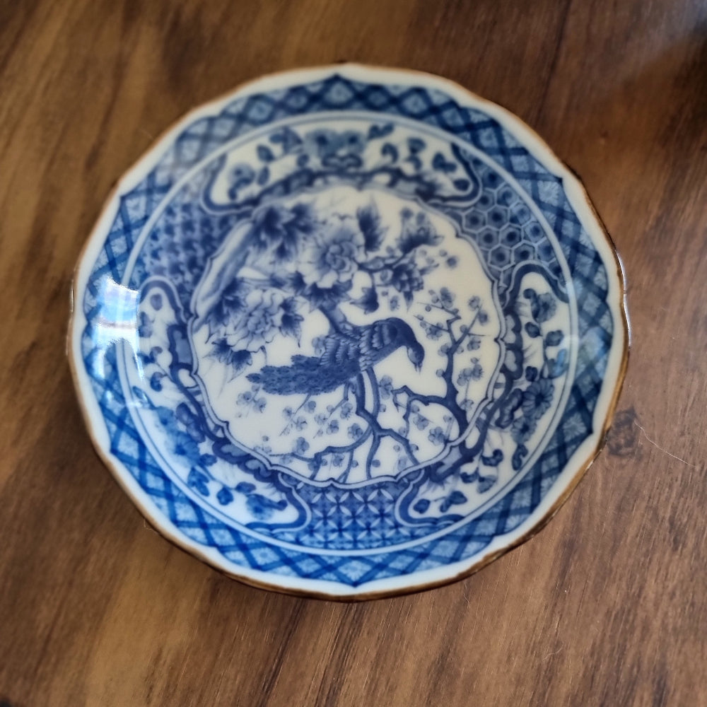 Vintage blue and white porcelain dish with bird and floral motif and scalloped edge
