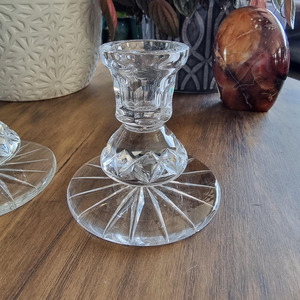 Pair of clear cut glass candle holders with starburst base design.