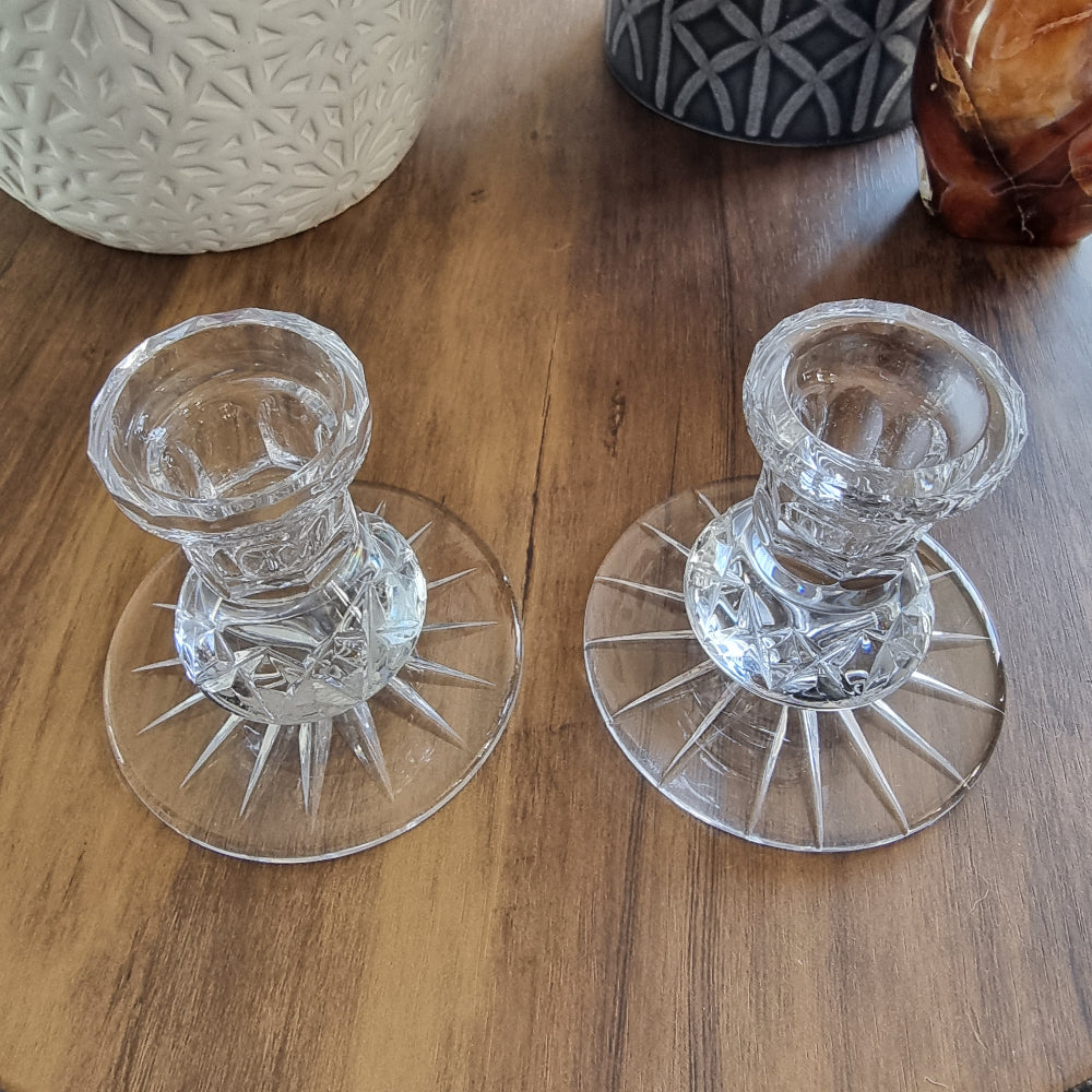 Pair of clear cut glass candle holders with starburst base design.