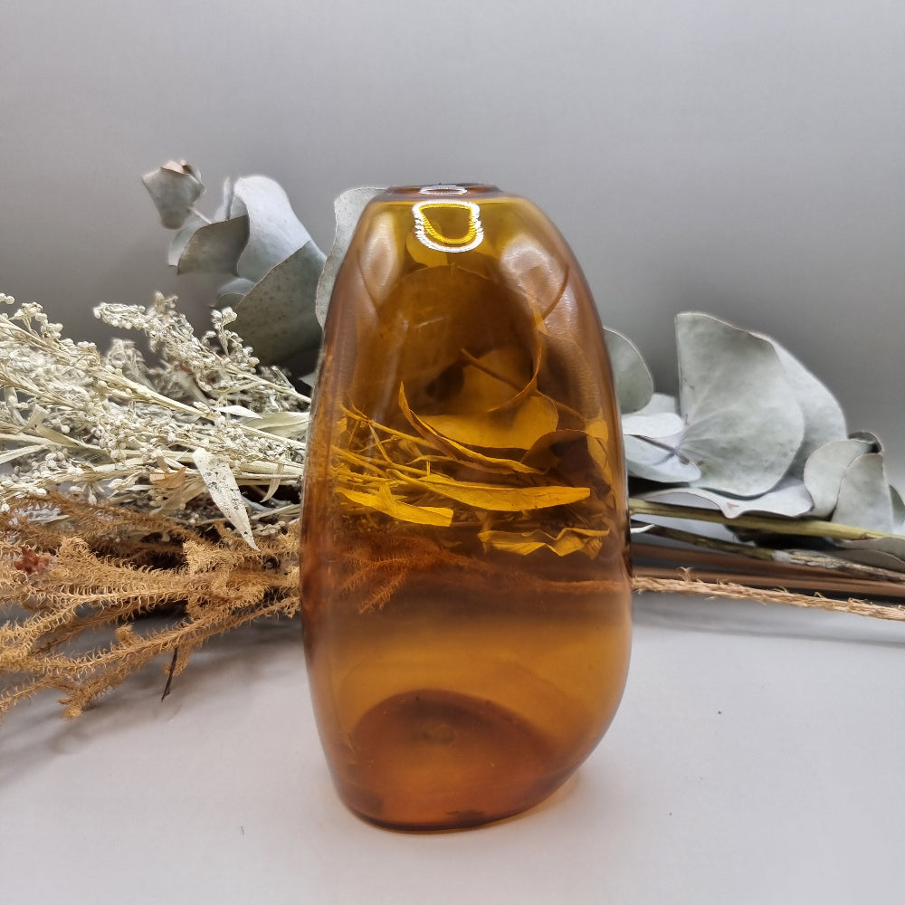 Amber handblown vase with smooth curved shape and small top opening.