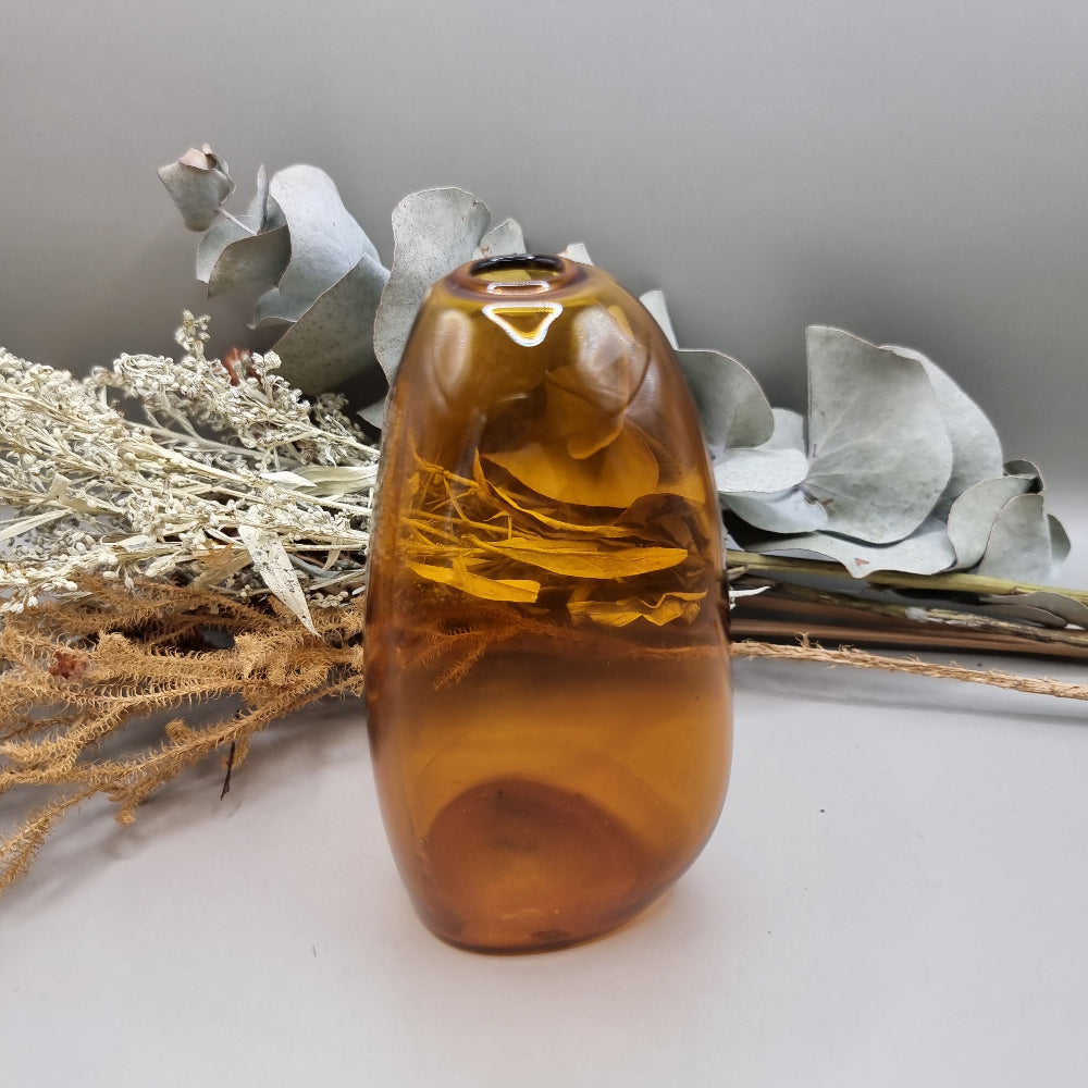 Amber handblown vase with smooth curved shape and small top opening.