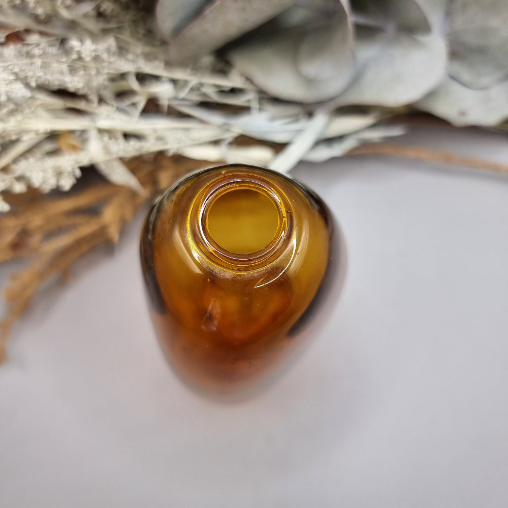 Amber handblown vase with smooth curved shape and small top opening.