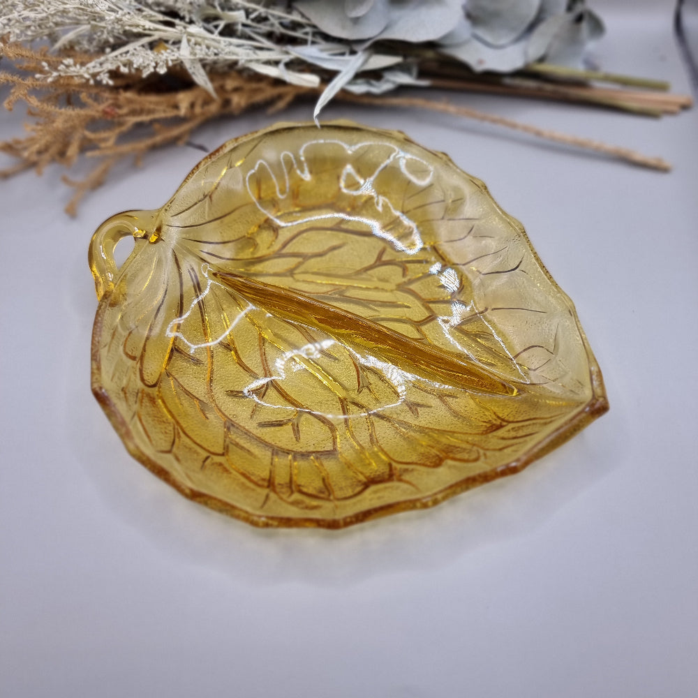 Amber pressed glass dish shaped like a leaf with detailed veins and small handle.