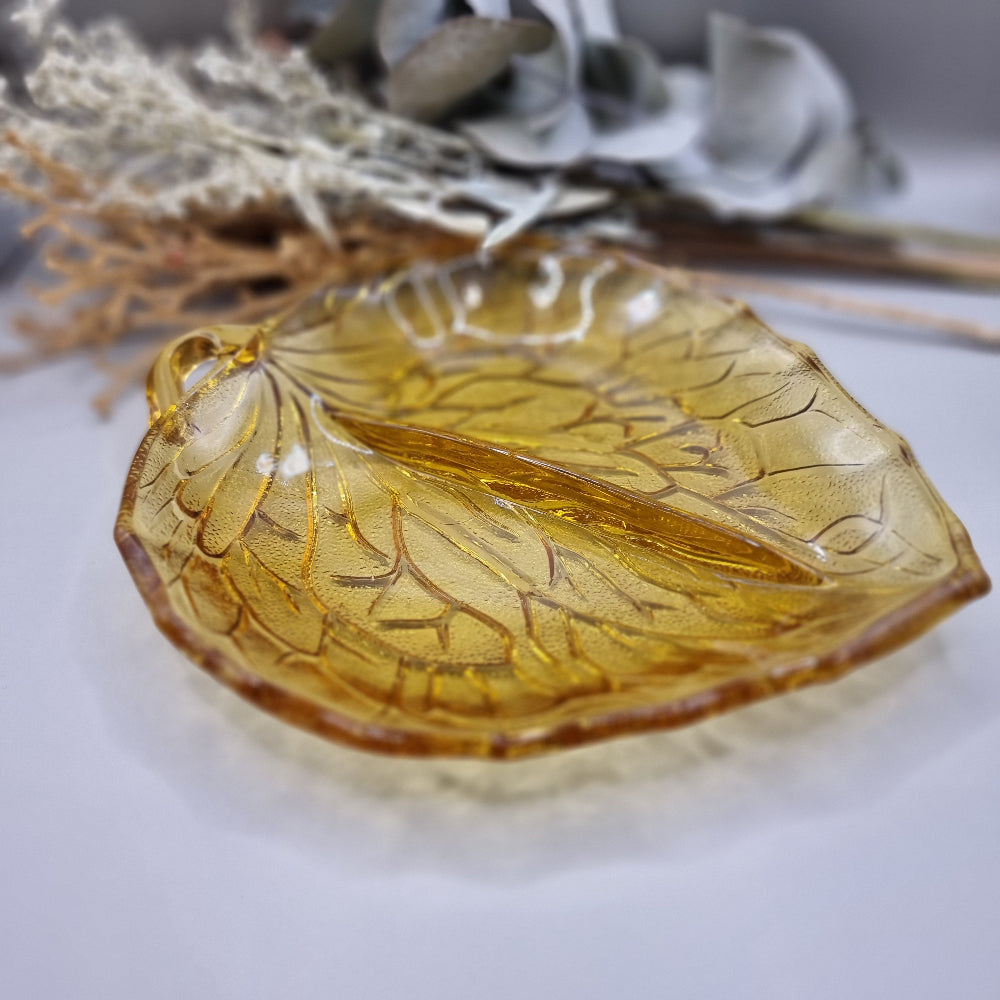 Amber pressed glass dish shaped like a leaf with detailed veins and small handle.