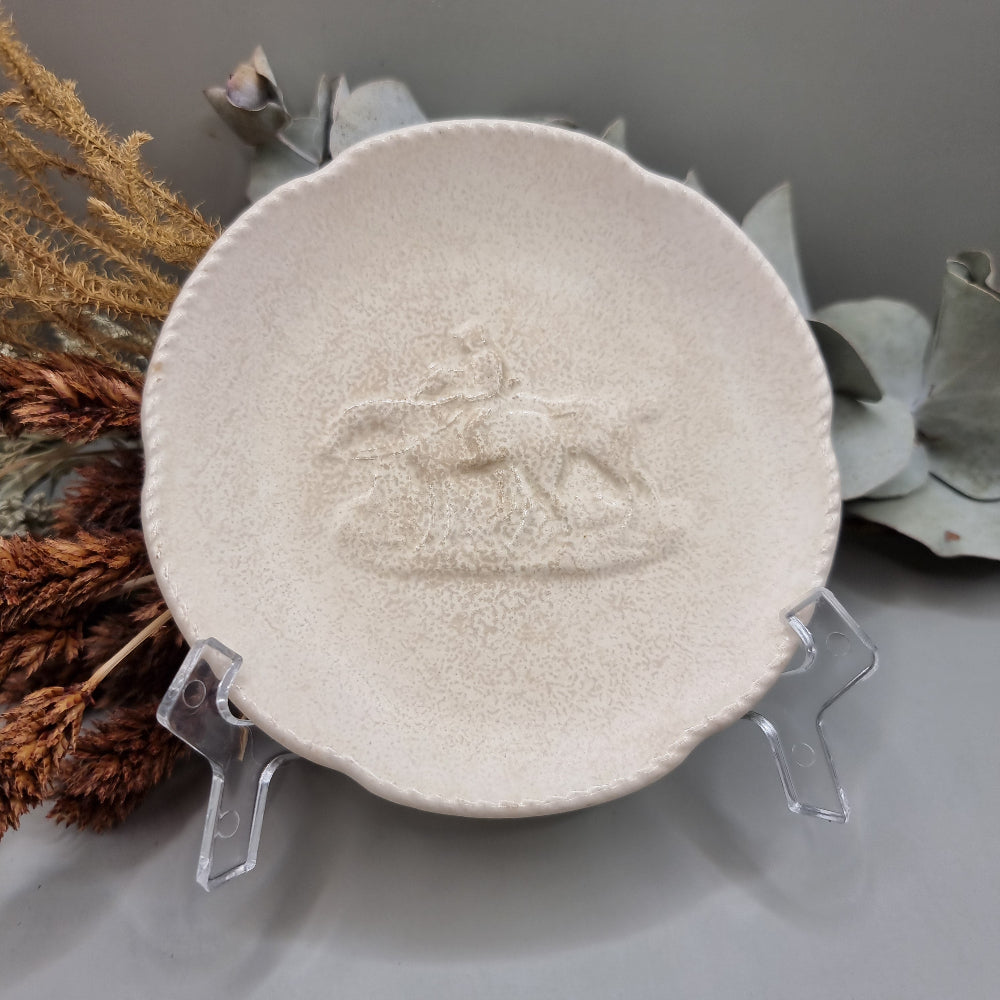Spode Velamour plate with embossed horse and rider motif on a textured cream glaze.