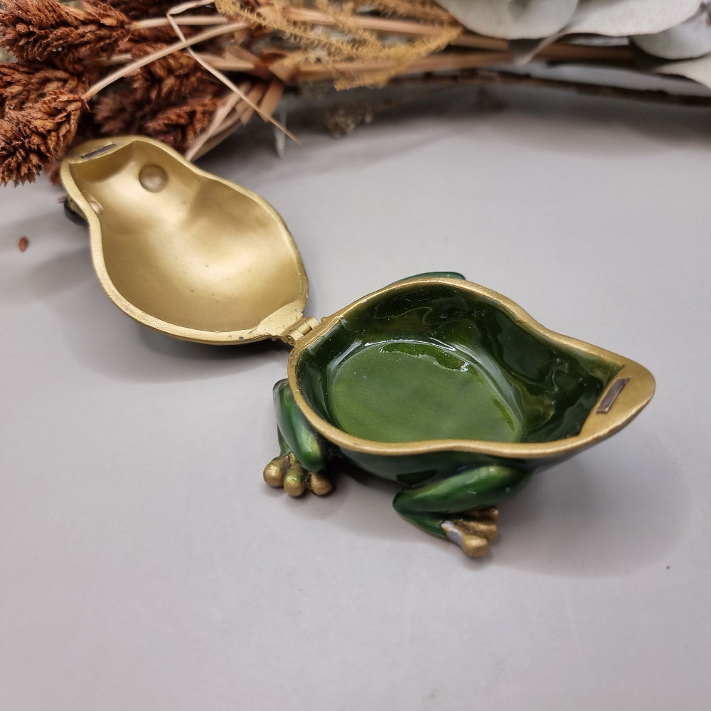 Green enamel frog trinket box with gold trim and rhinestones.