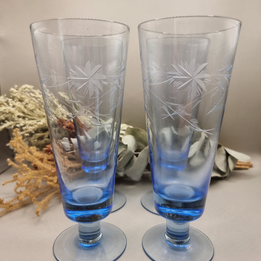 Set of four blue etched starburst glasses with footed base