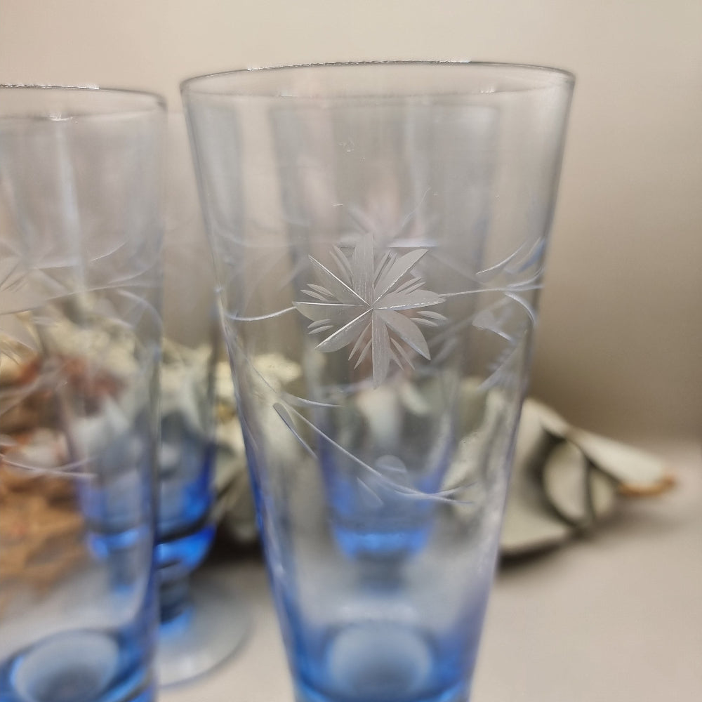 Set of four blue etched starburst glasses with footed base