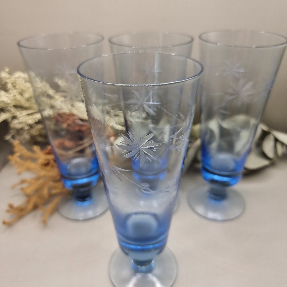 Set of four blue etched starburst glasses with footed base
