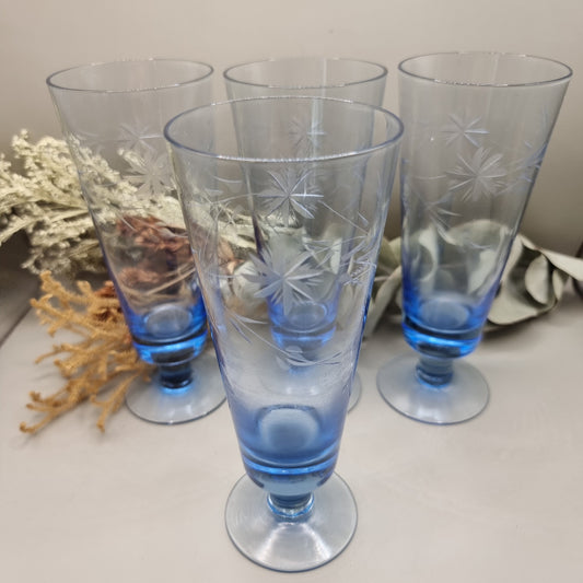 Set of four blue etched starburst glasses with footed base