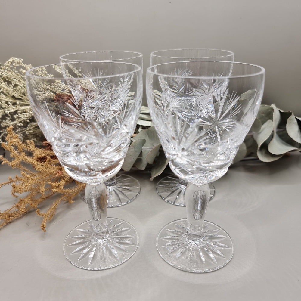 Set of four cut crystal wine goblets with intricate starburst design