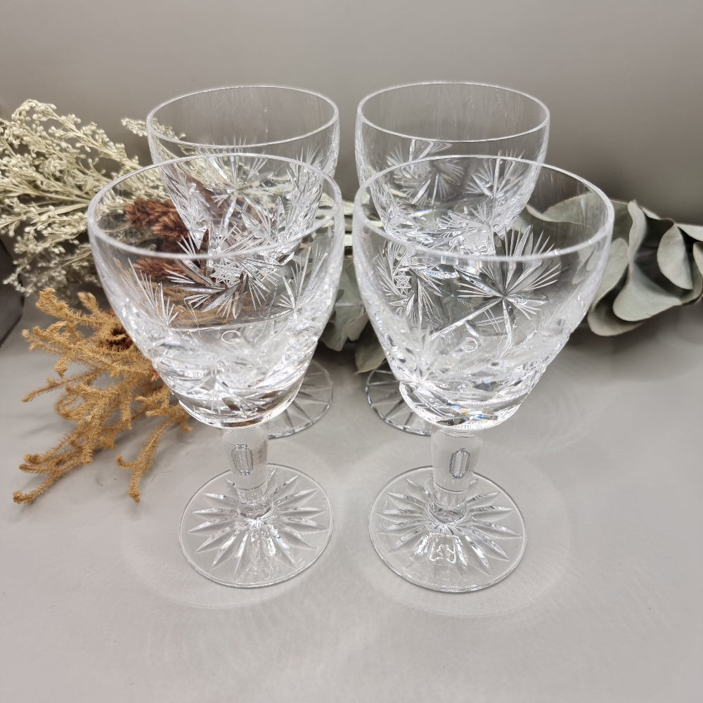 Set of four cut crystal wine goblets with intricate starburst design