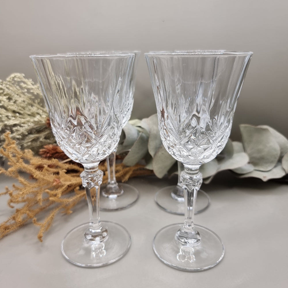 Set of four cut crystal goblets with faceted stems and traditional crisscross pattern