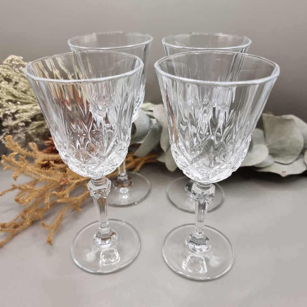 Set of four cut crystal goblets with faceted stems and traditional crisscross pattern