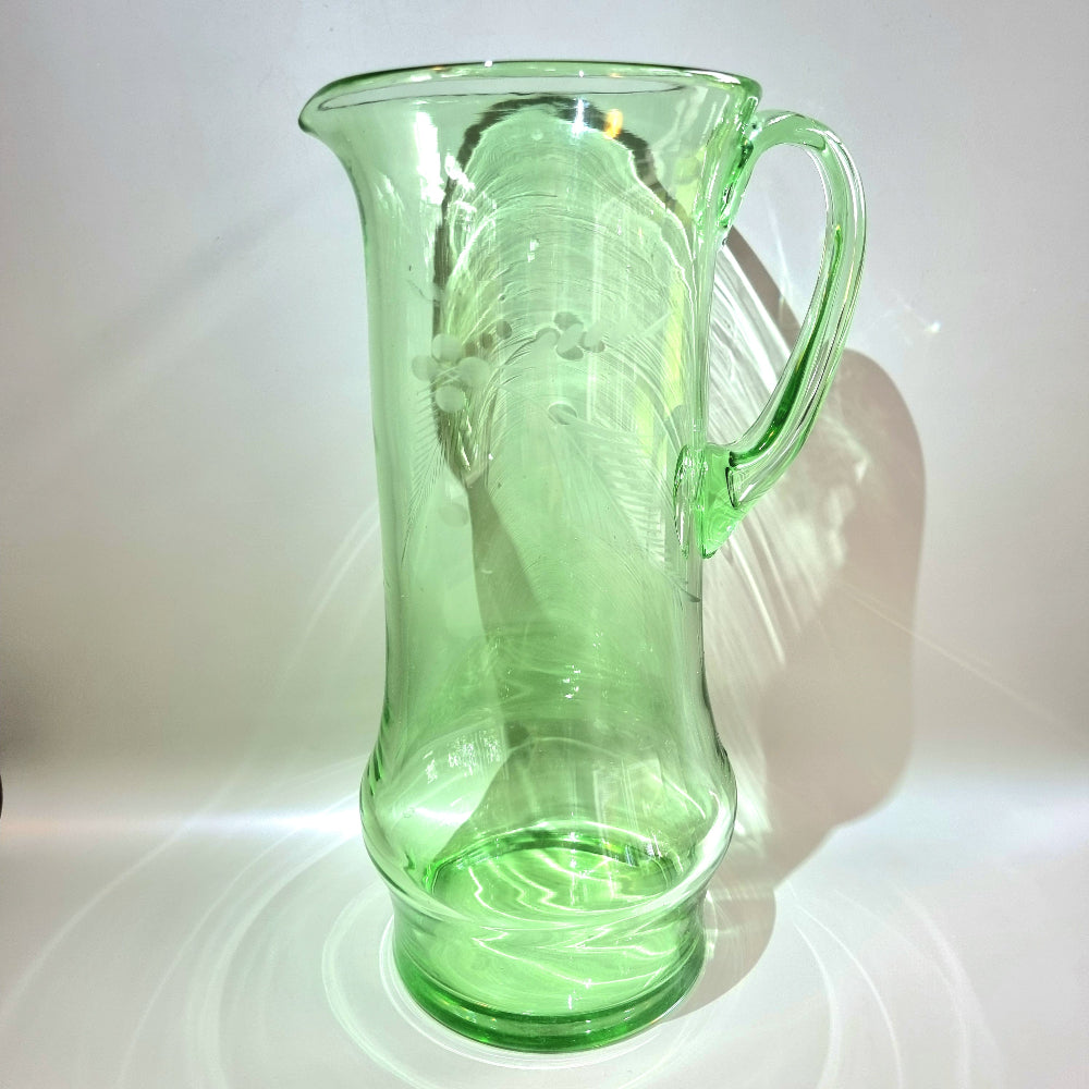 Tall green glass jug with etched floral and fern design and flared rim