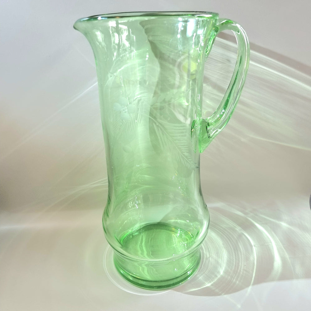 Tall green glass jug with etched floral and fern design and flared rim
