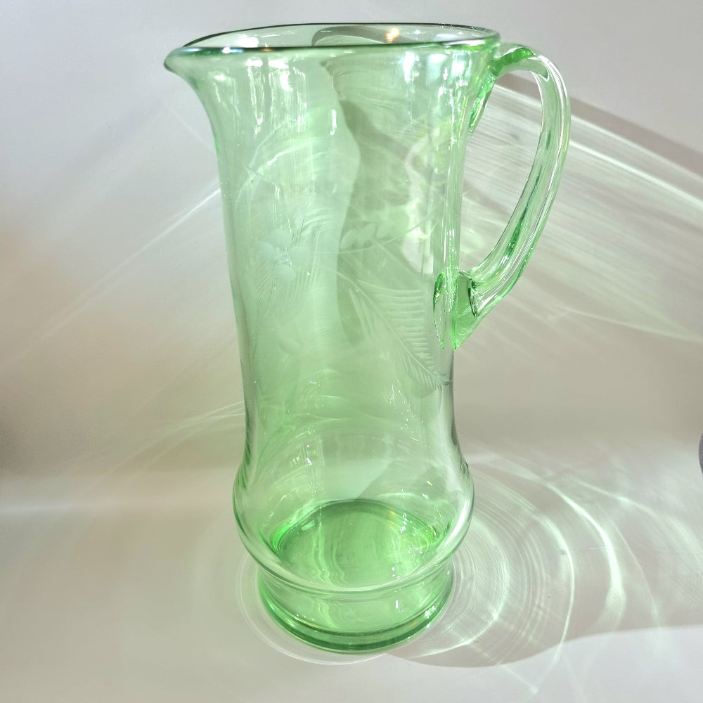 Tall green glass jug with etched floral and fern design and flared rim