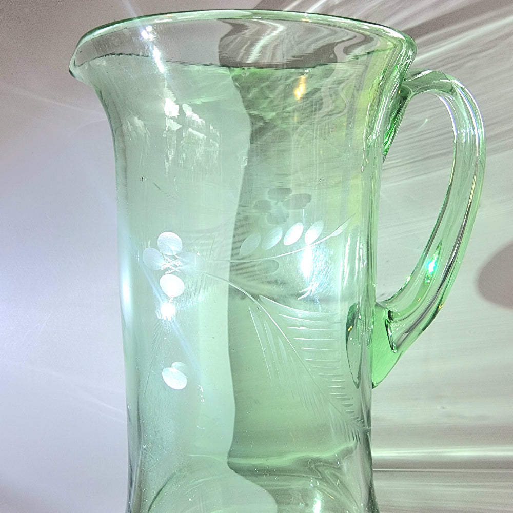 Tall green glass jug with etched floral and fern design and flared rim