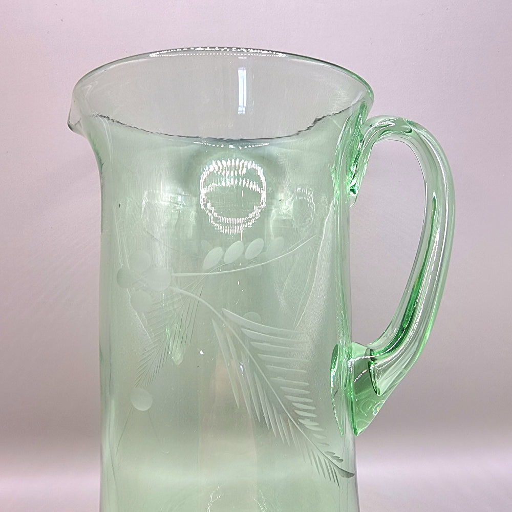 Tall green glass jug with etched floral and fern design and flared rim