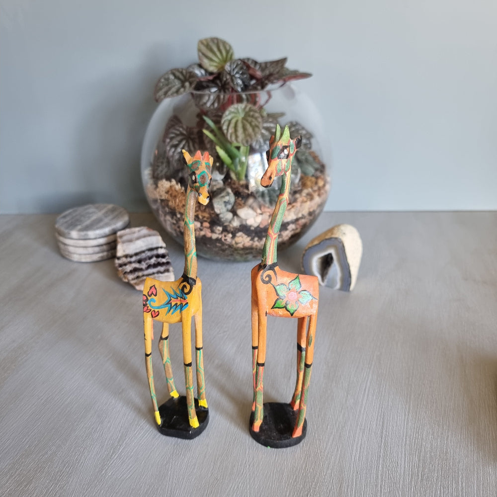 Pair of hand-painted wooden giraffe figurines with colourful folk art designs.