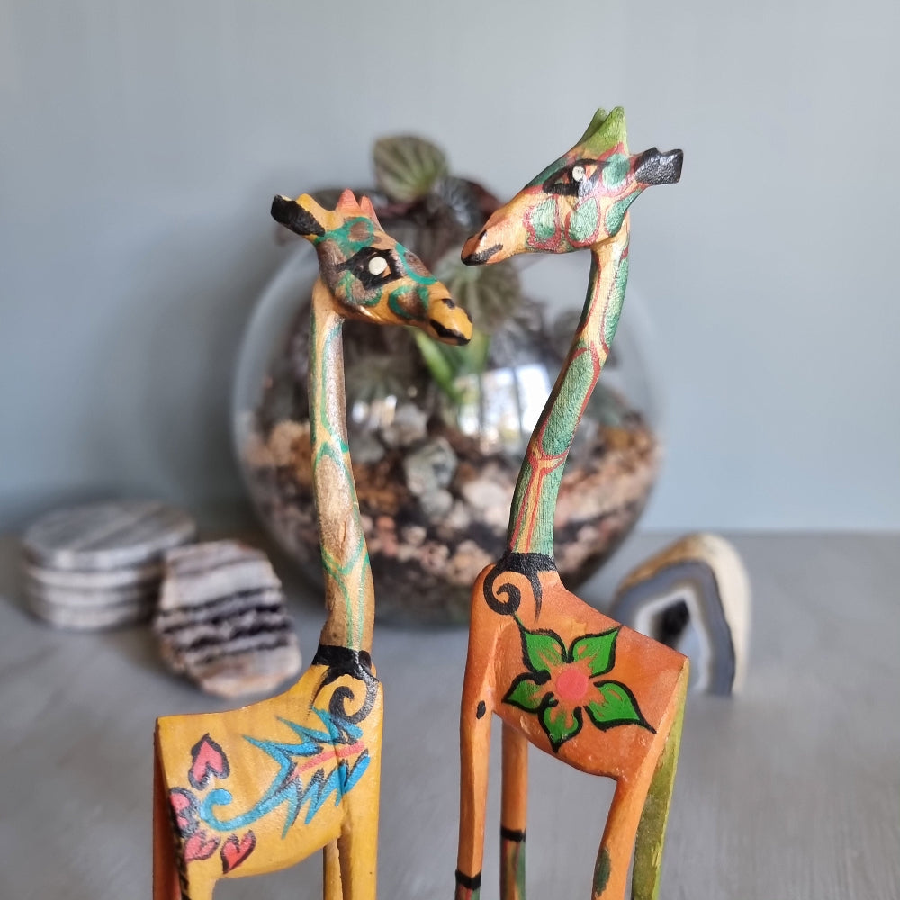 Pair of hand-painted wooden giraffe figurines with colourful folk art designs.