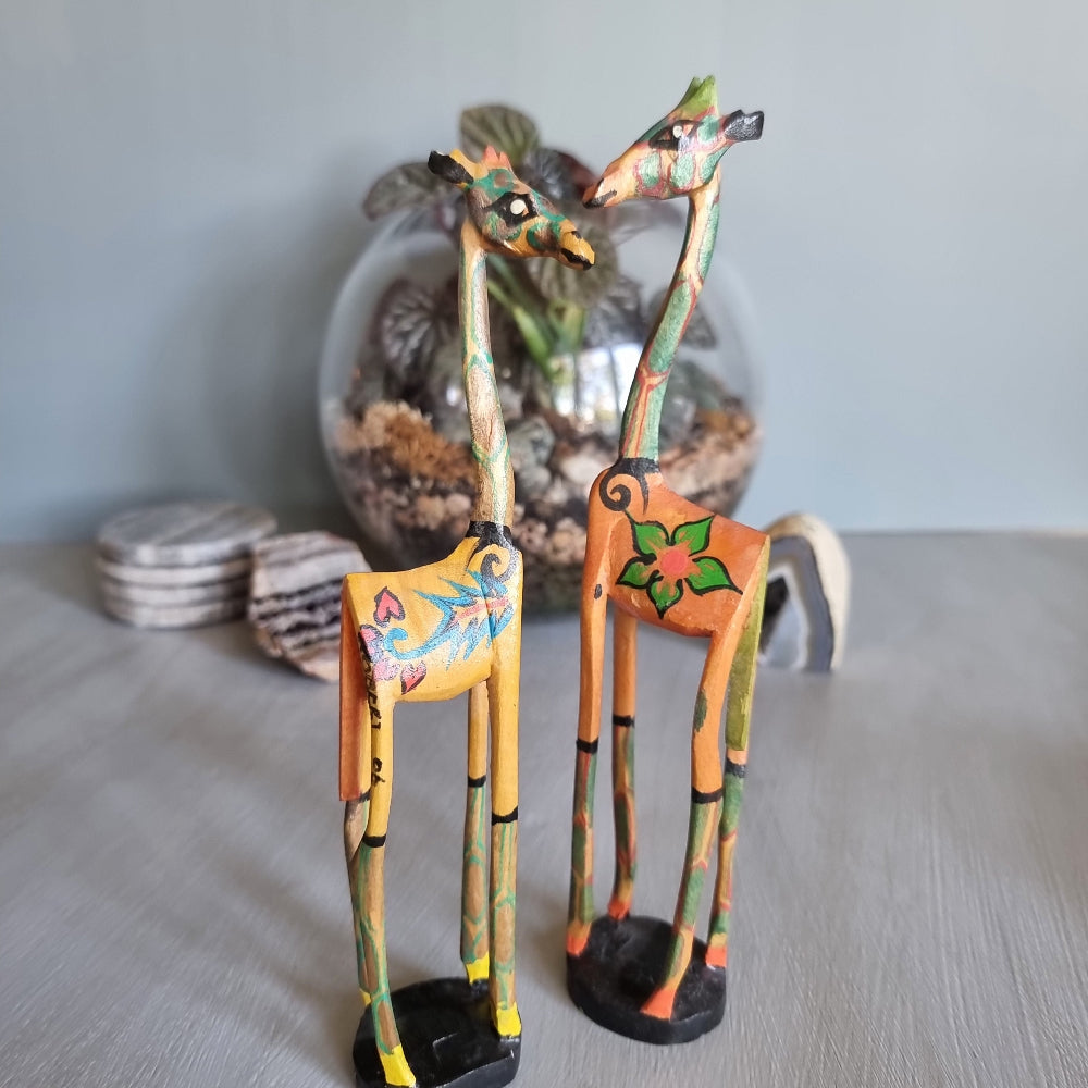 Pair of hand-painted wooden giraffe figurines with colourful folk art designs.