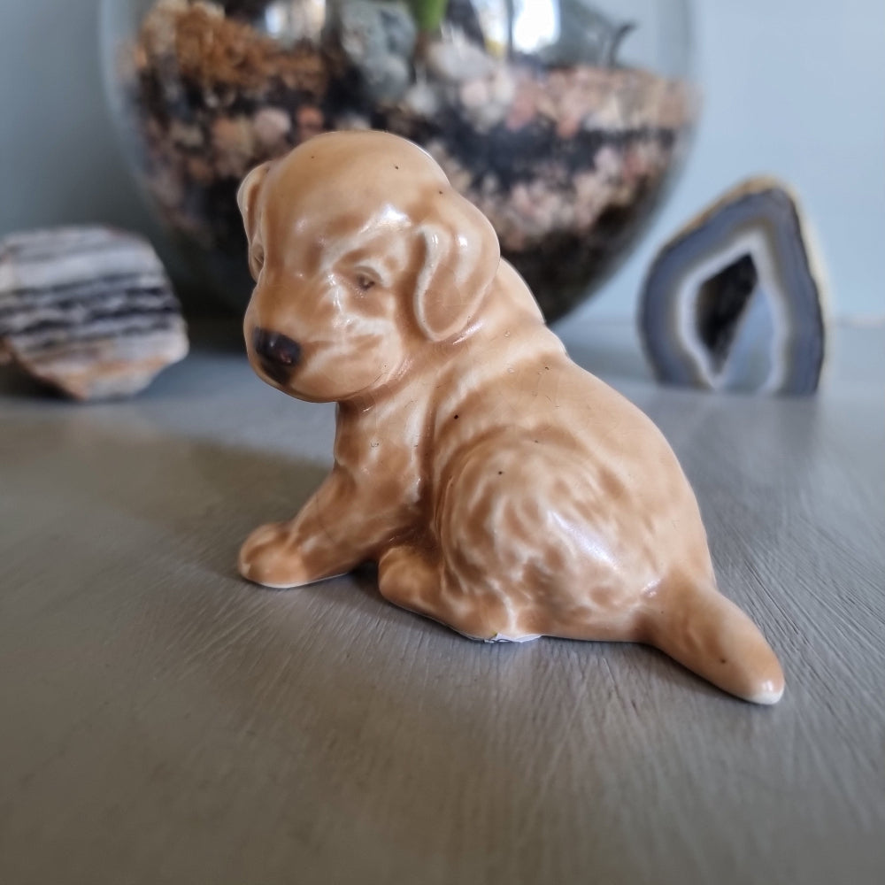 Vintage ceramic puppy figurine in caramel tones, seated with soft expression.