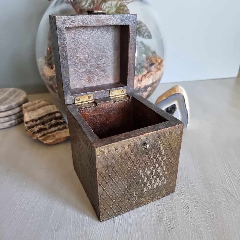 Square wooden box with diamond brass embossing and hinged lid.