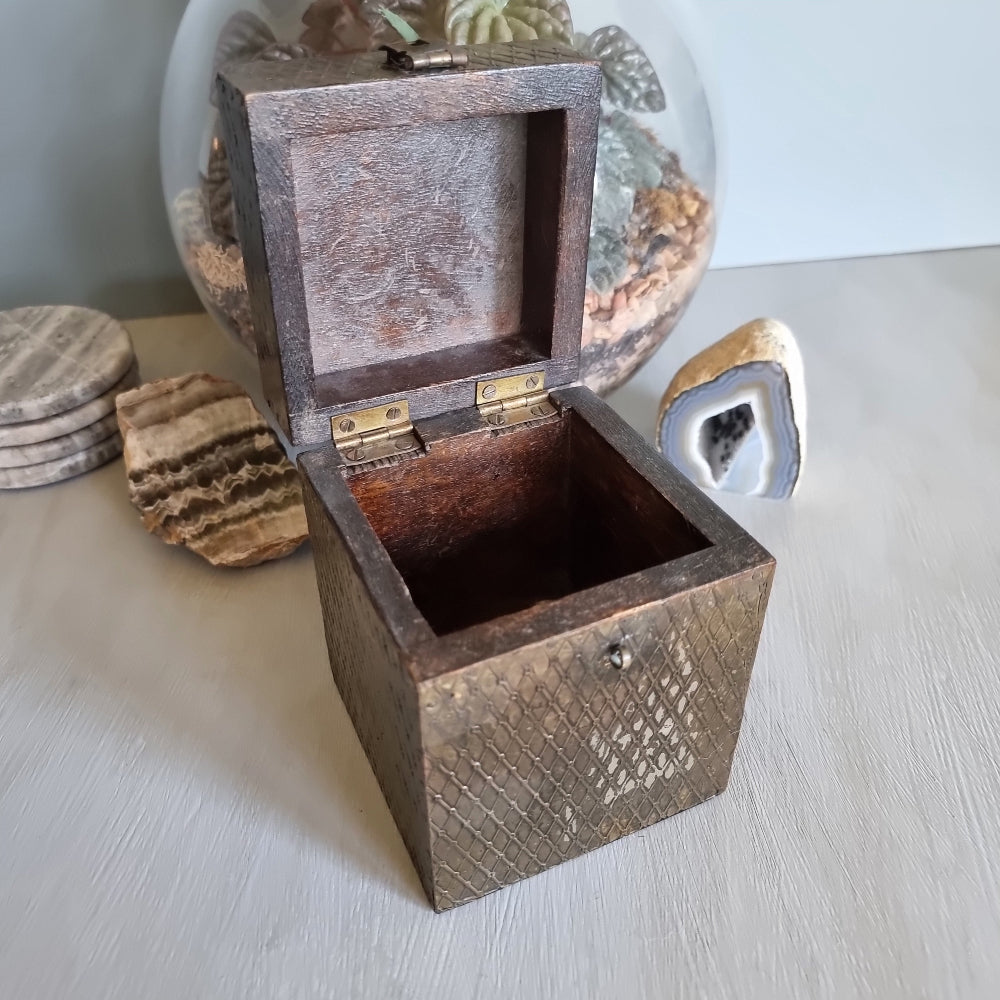Square wooden box with diamond brass embossing and hinged lid.
