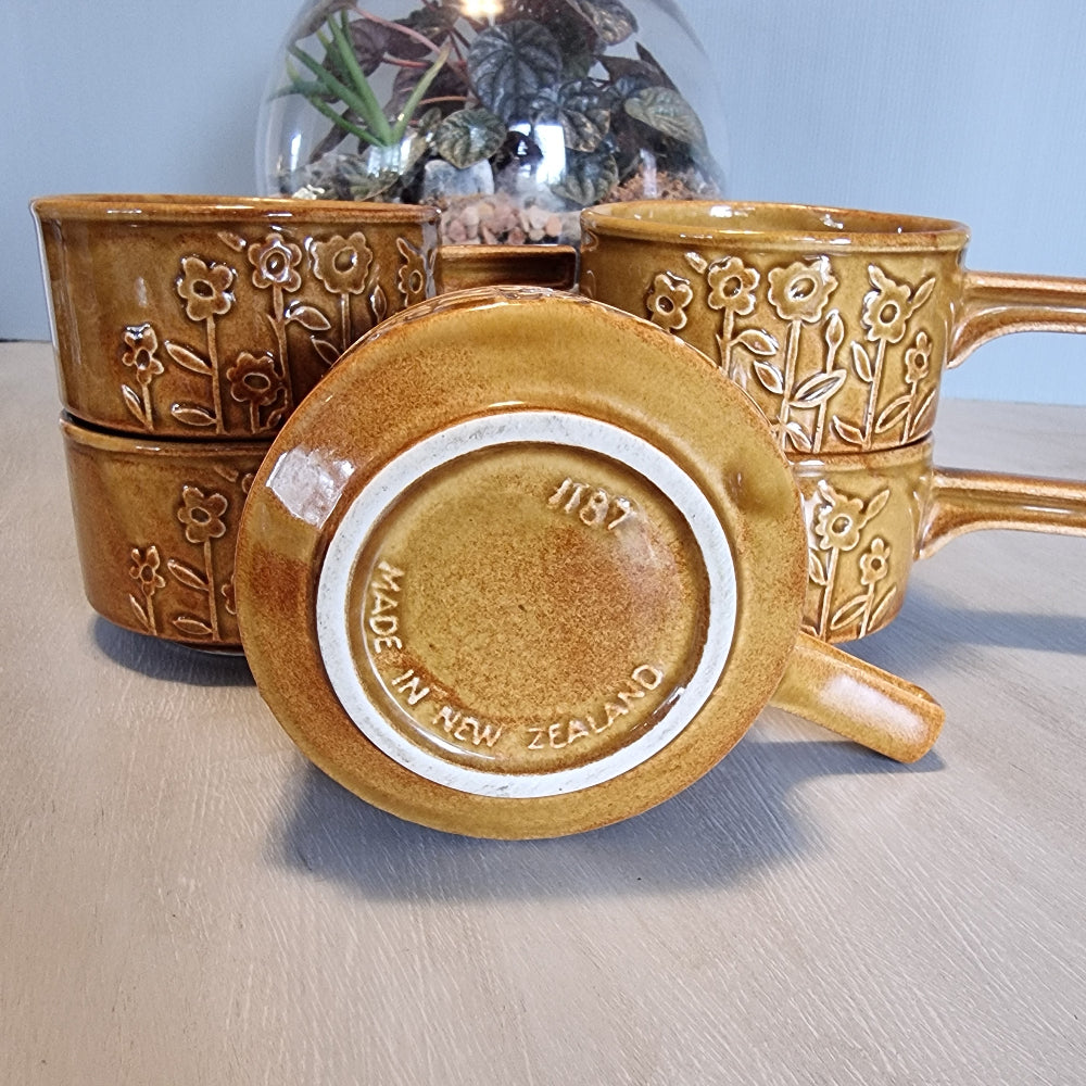 Set of 5 Crown Lynn brown soup bowls with embossed floral design and handles.