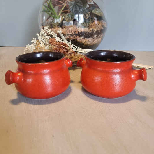 Pair of vintage red ceramic soup bowls with double handles and black interior.