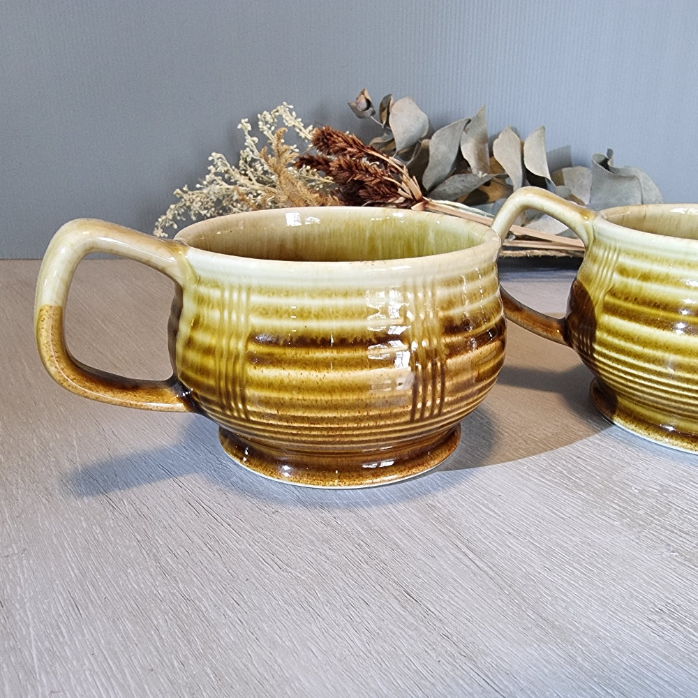 Pair of vintage brown drip-glaze ceramic soup mugs with ribbed design and handles.