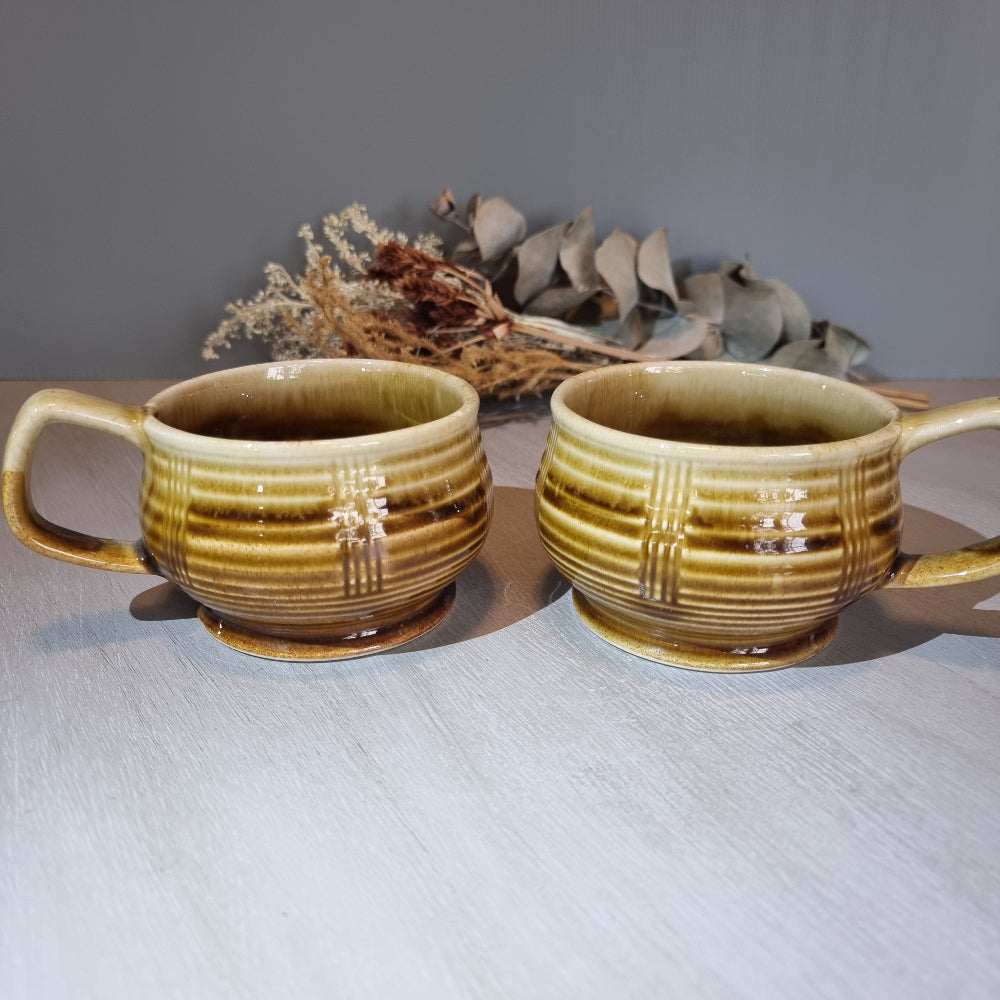 Pair of vintage brown drip-glaze ceramic soup mugs with ribbed design and handles.