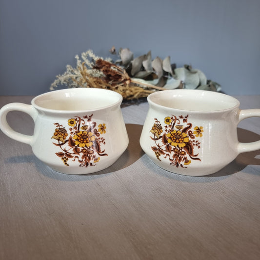 Pair of Crown Lynn soup mugs with golden floral design on cream glaze.