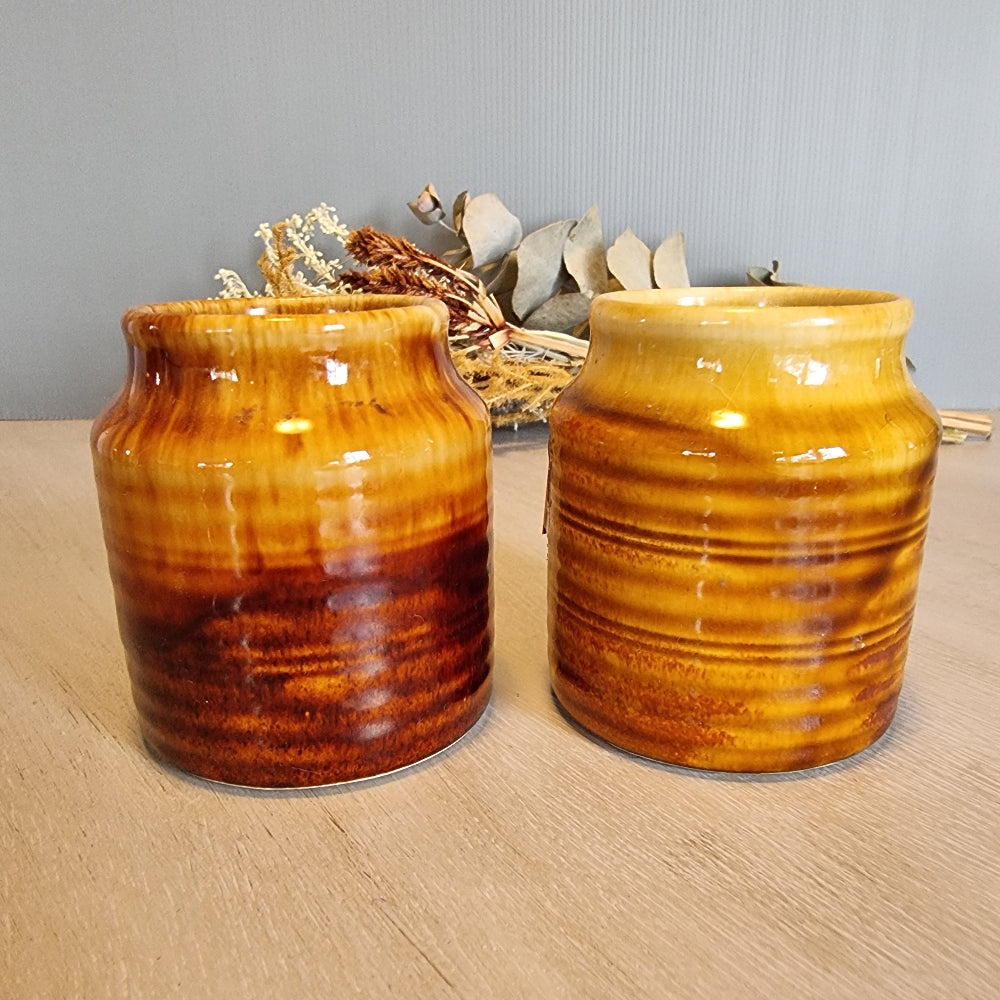 Pair of Crown Lynn drip glaze jars in golden brown tones.