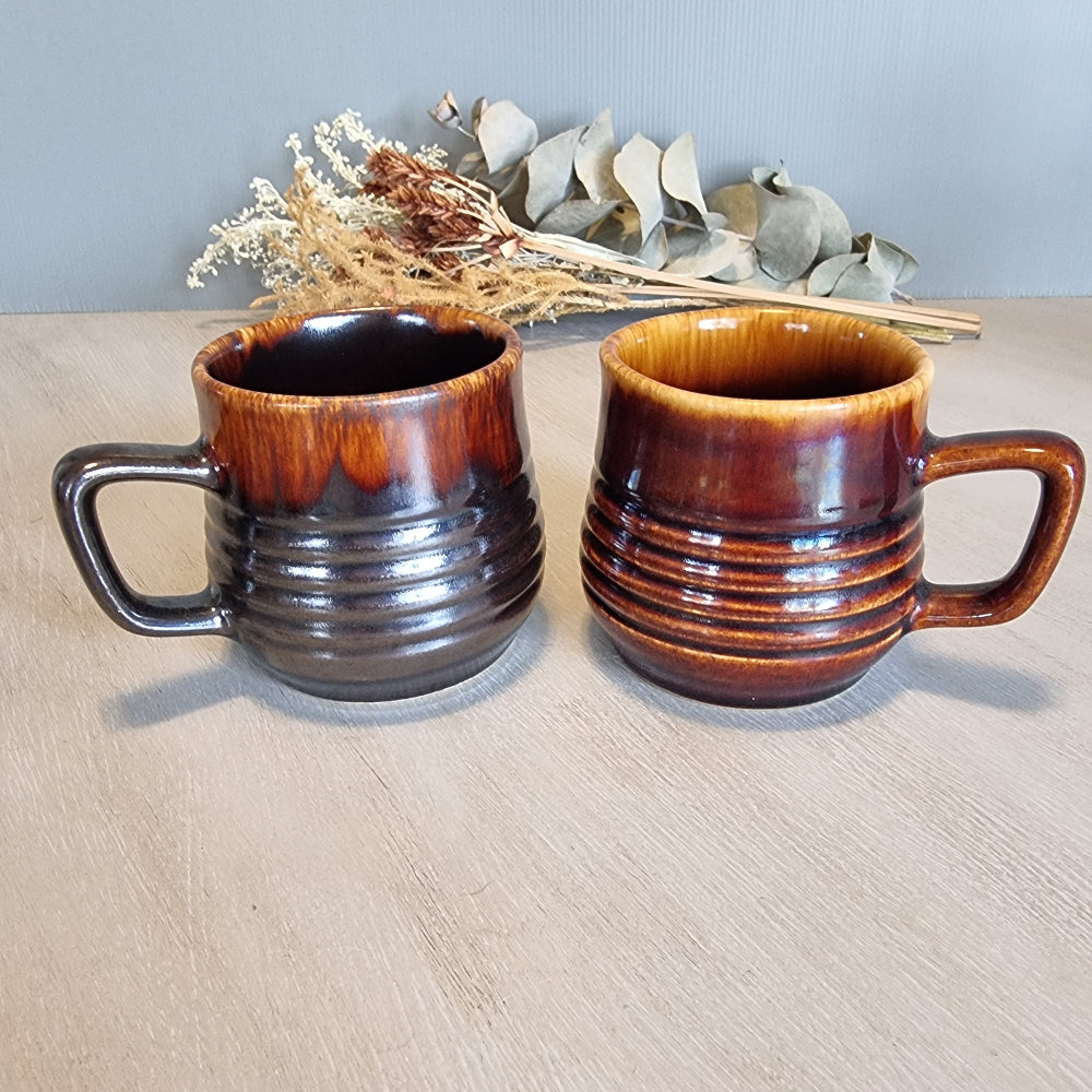 Pair of Crown Lynn ribbed mugs with brown drip glazes.