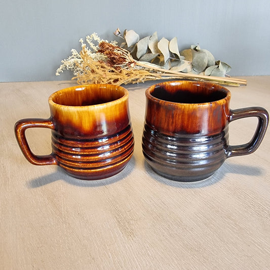Pair of Crown Lynn ribbed mugs with brown drip glazes.