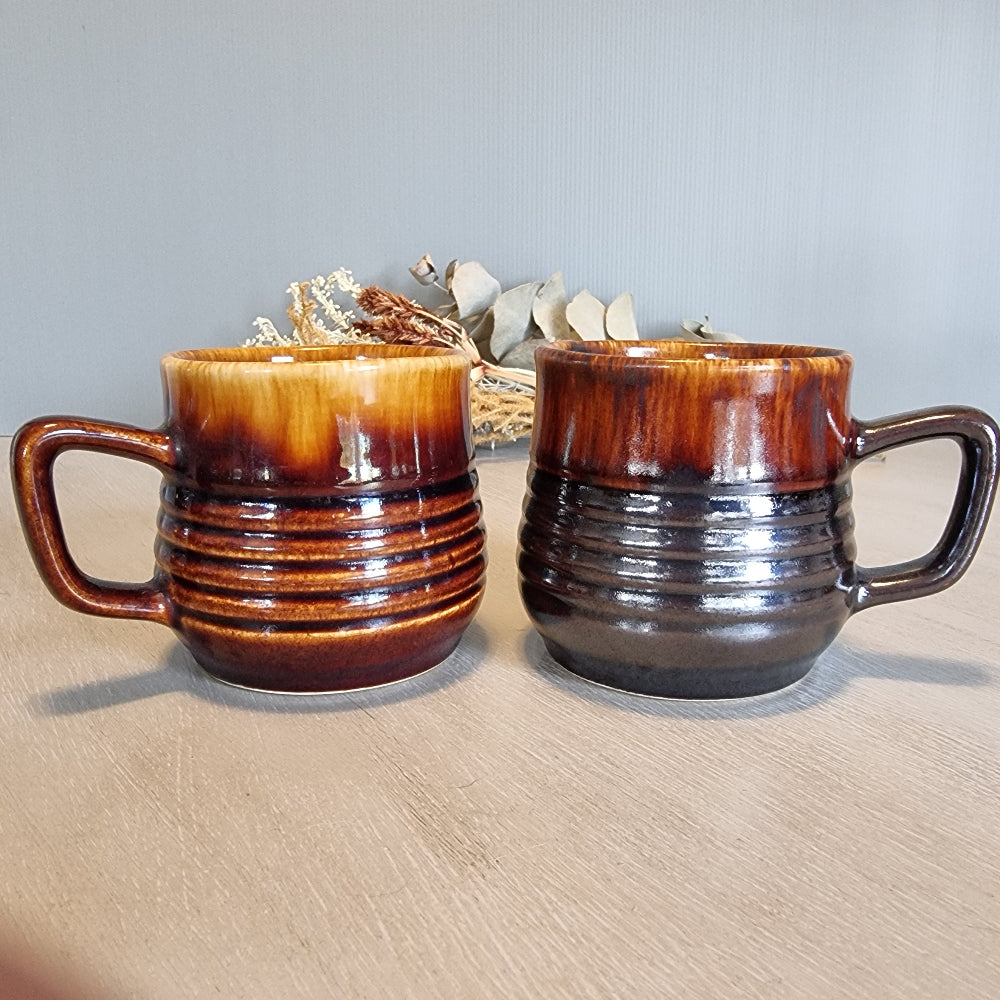 Pair of Crown Lynn ribbed mugs with brown drip glazes.