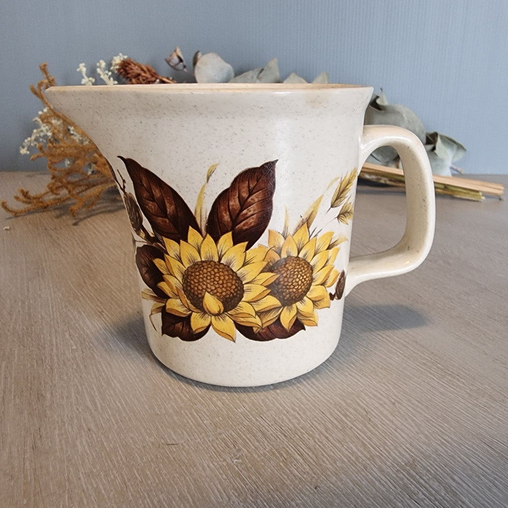 Vintage ceramic jug with bold sunflower design on speckled base.