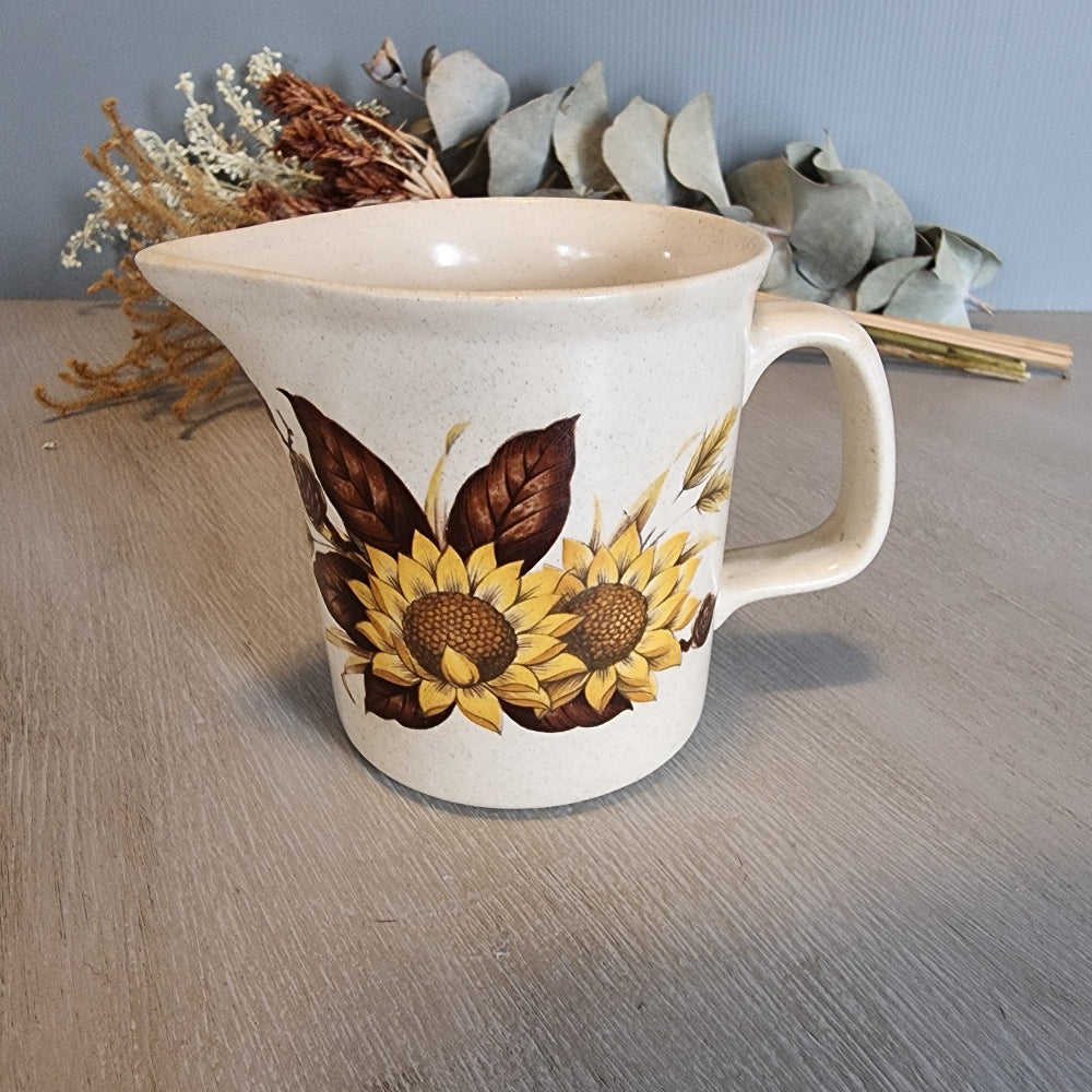 Vintage ceramic jug with bold sunflower design on speckled base.