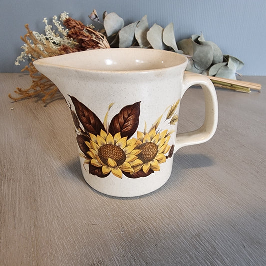 Vintage ceramic jug with bold sunflower design on speckled base.