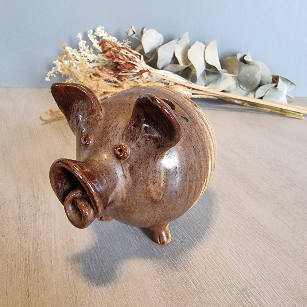 Vintage brown ceramic pig figurine with glossy glaze and open holes across the top