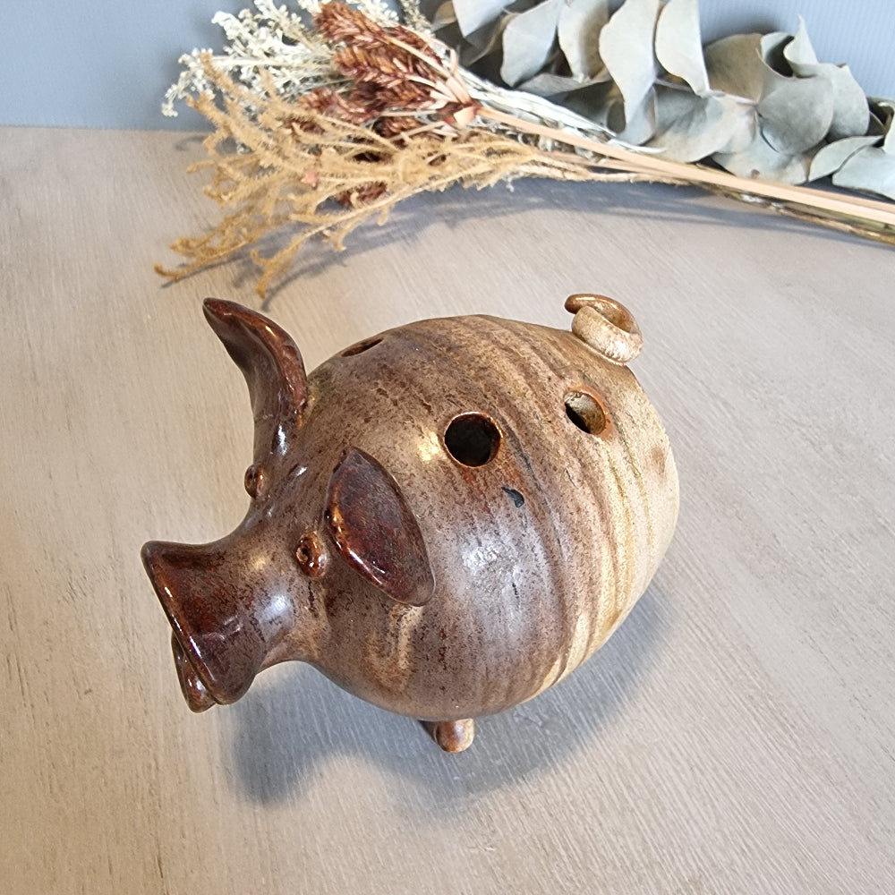 Vintage brown ceramic pig figurine with glossy glaze and open holes across the top