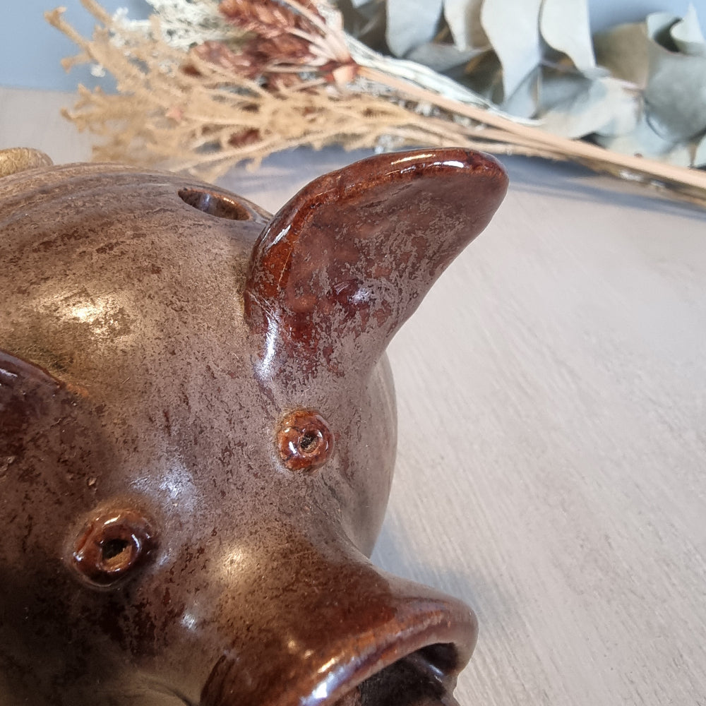 Vintage brown ceramic pig figurine with glossy glaze and open holes across the top