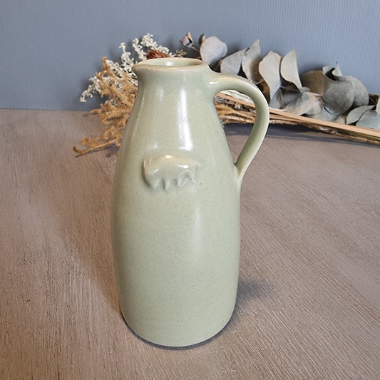 Green ceramic jug with embossed buffalo motif, rustic farmhouse kitchen collectible.