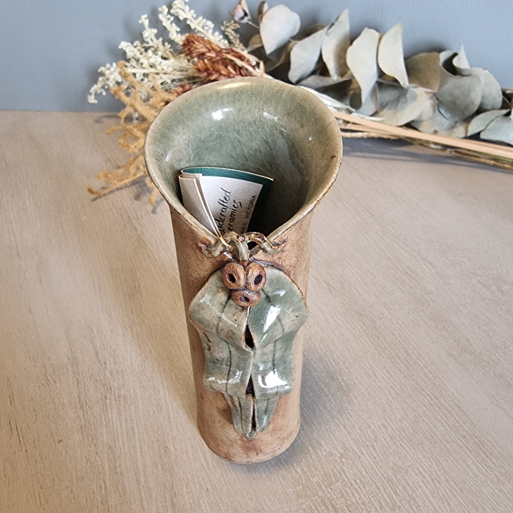 Sharon Twining handcrafted ceramic vase with gumleaf and gumnut design, earthy Australian pottery.