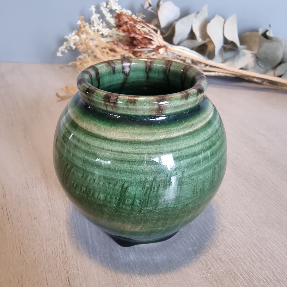 Vintage round green glazed pottery vase with drip glaze and small feet.