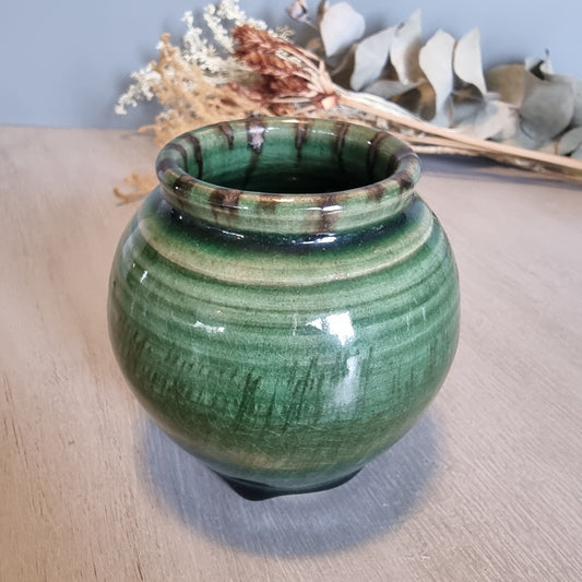 Vintage round green glazed pottery vase with drip glaze and small feet.