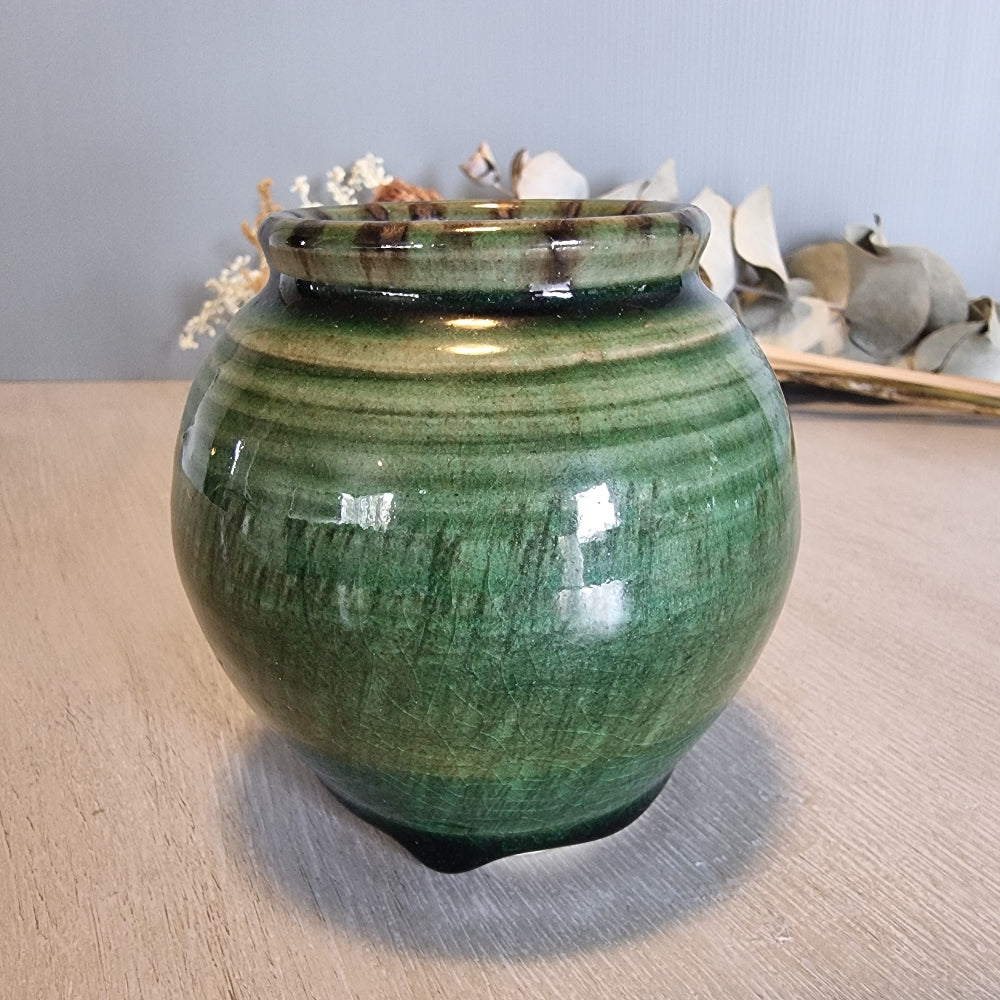 Vintage round green glazed pottery vase with drip glaze and small feet.